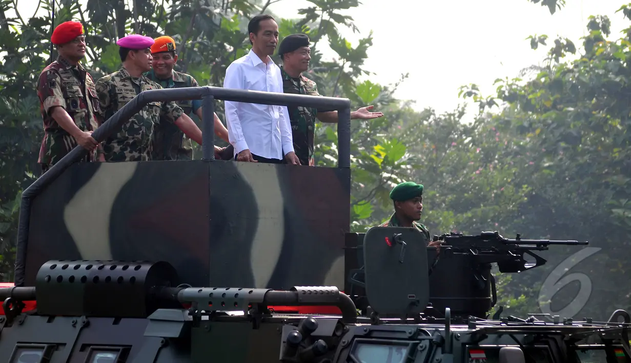 Presiden Joko Widodo saat menaiki Panser Anoa ditemani panglima TNI Jenderal Moeldoko dan Para Kepala Kesatuan jelang upacara pengangkatan dirinya sebagai warga kehormatan pasukan khusus TNI, Kamis (16/4/2015). (Liputan6.com/Yoppy Renato)