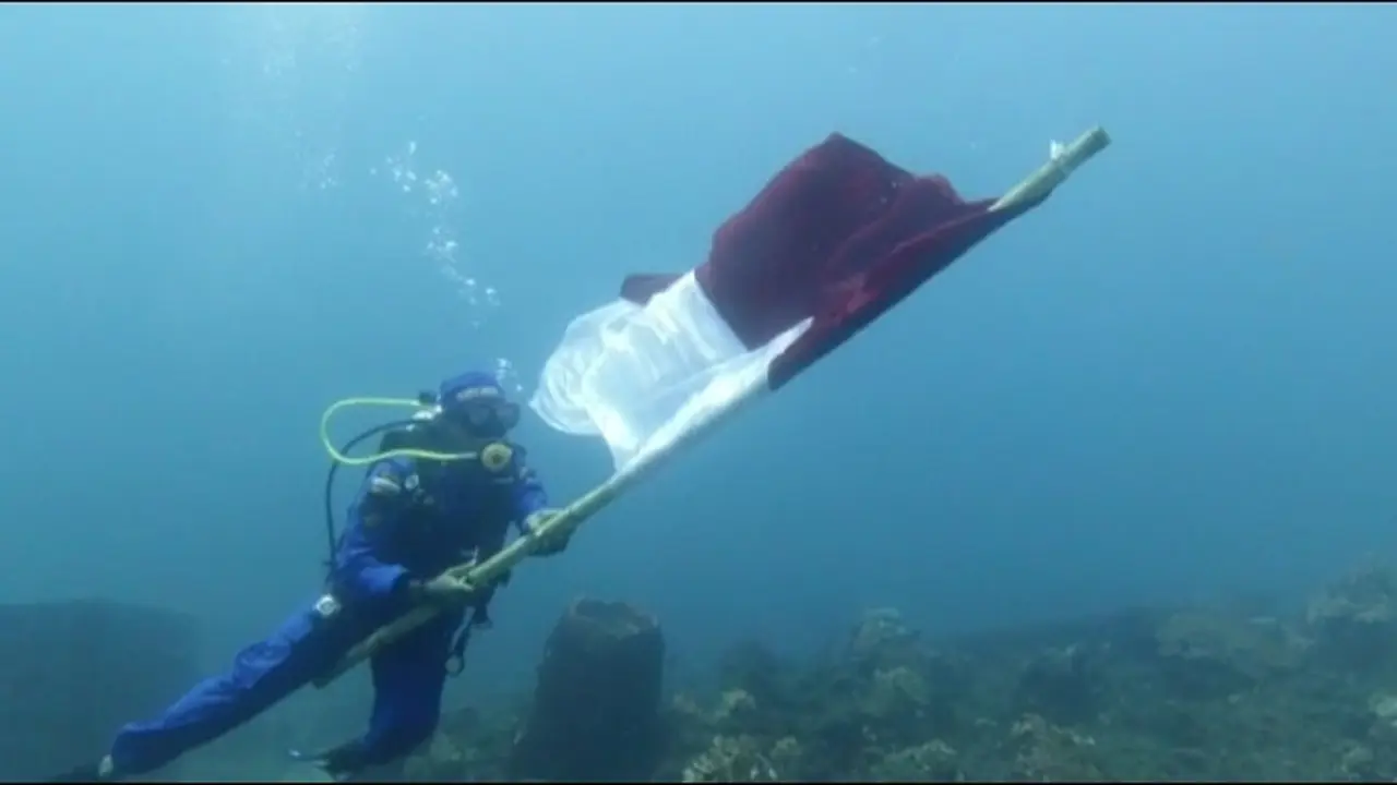 Personil Satpol Air Banyuwangi melakukan pengibaran bendera merah putih di laut Selat Bali (Istimewa)