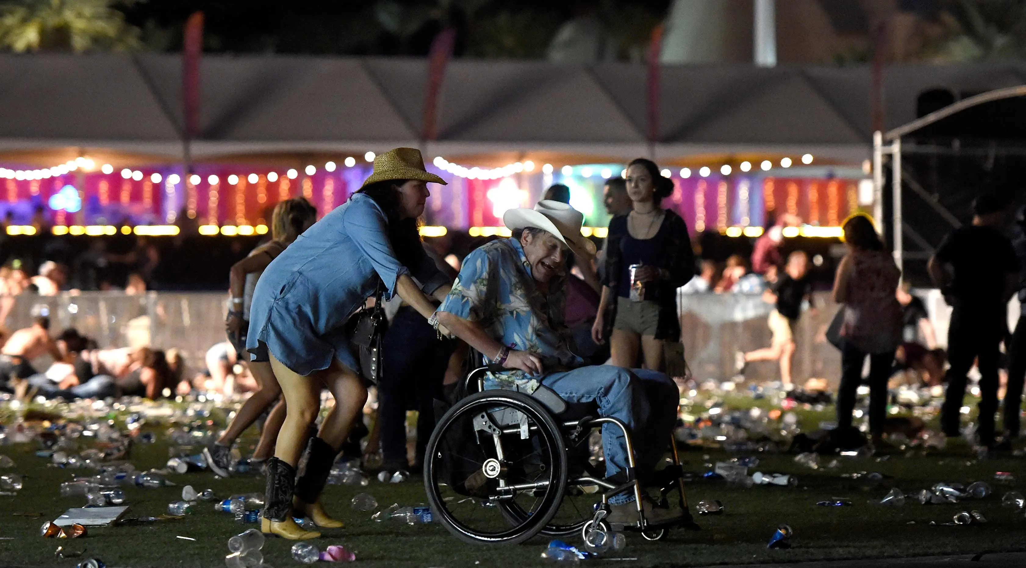 Pengunjung mengenakan kursi roda menghindar saat terjadi penembakan di Las Vegas, Nevada (1/10). Pelaku penembakan disebut menembak seorang petugas keamanan dan polisi setempat. (David Becker/Getty Images/AFP)