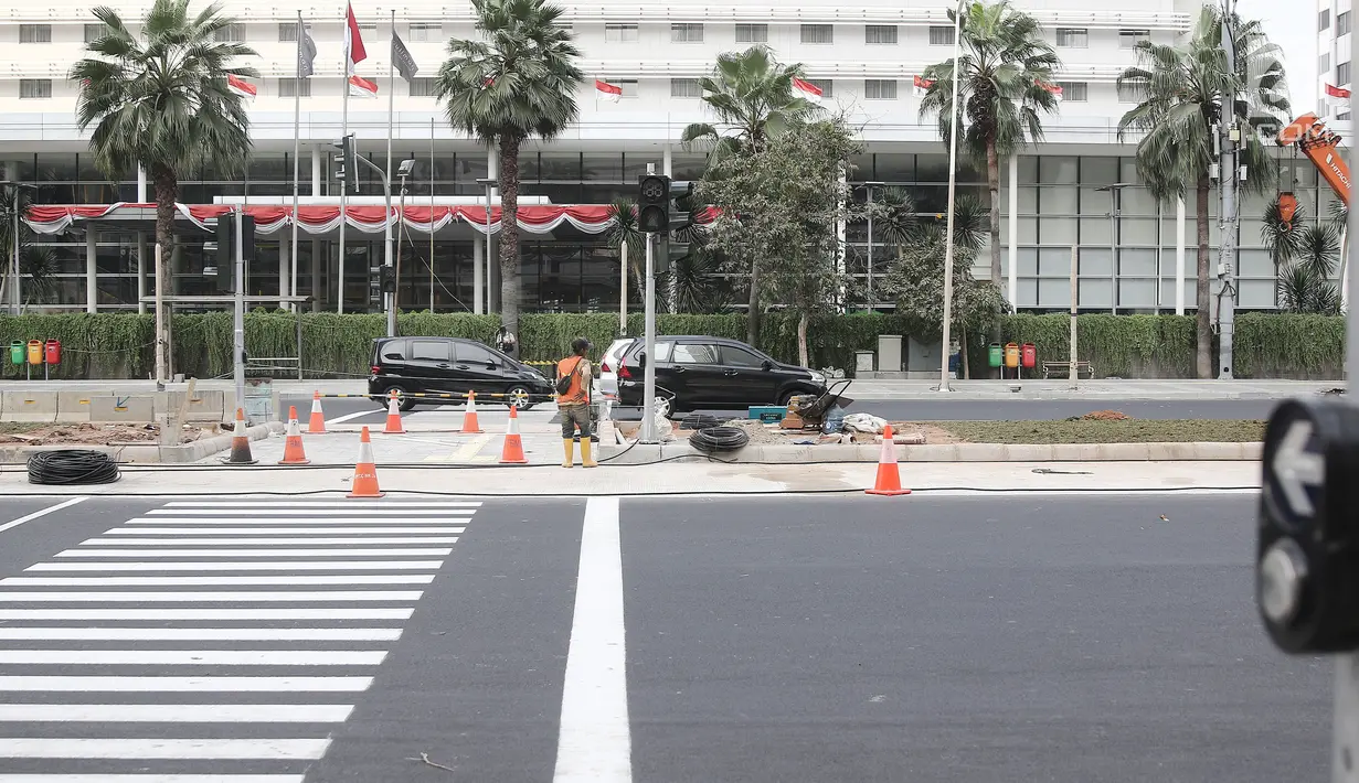 Pekerja menyelesaikan Pelican Crossing atau jalur khusus penyeberangan orang di kawasan Thamrin, Jakarta, Minggu (29/7). Gubernur DKI Anies Baswedan mengatakan Pelican Crossing ini mulai beroperasi pada 6 Agustus mendatang. (Liputan6.cpm/Herman Zakharia)