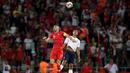 Striker Turki, Burak Yilmaz, duel udara dengan bek Prancis, Raphael Varane, pada laga kualifikasi Piala Eropa 2020 di Stadion Buyuksehir Belediyesi, Minggu (9/6). Turki menang 2-0 atas Prancis. (AFP/Bulent Kilic)