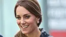 Kate Middleton terlihat cantik membawa bunga saat mengunjungi Meseum Nasional Sepak Bola di Manchester, Inggris (14/10). (Reuters/Charlotte Graham)