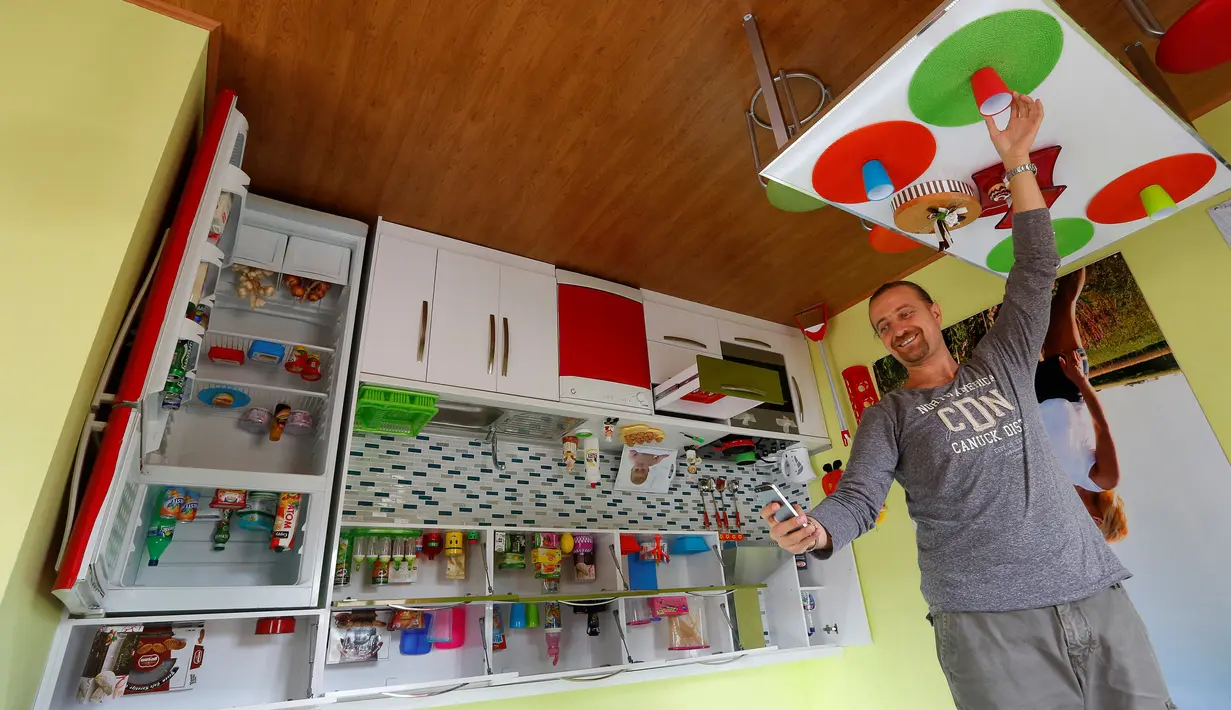 Seorang turis berselfie di ruang dapur rumah terbalik di kota resor Mediterania, Antalya, Turki, Sabtu (12/11). Keberadaan rumah terbalik ini menjadi daya tarik tersendiri untuk wisatawan. (REUTERS/Murad Sezer)