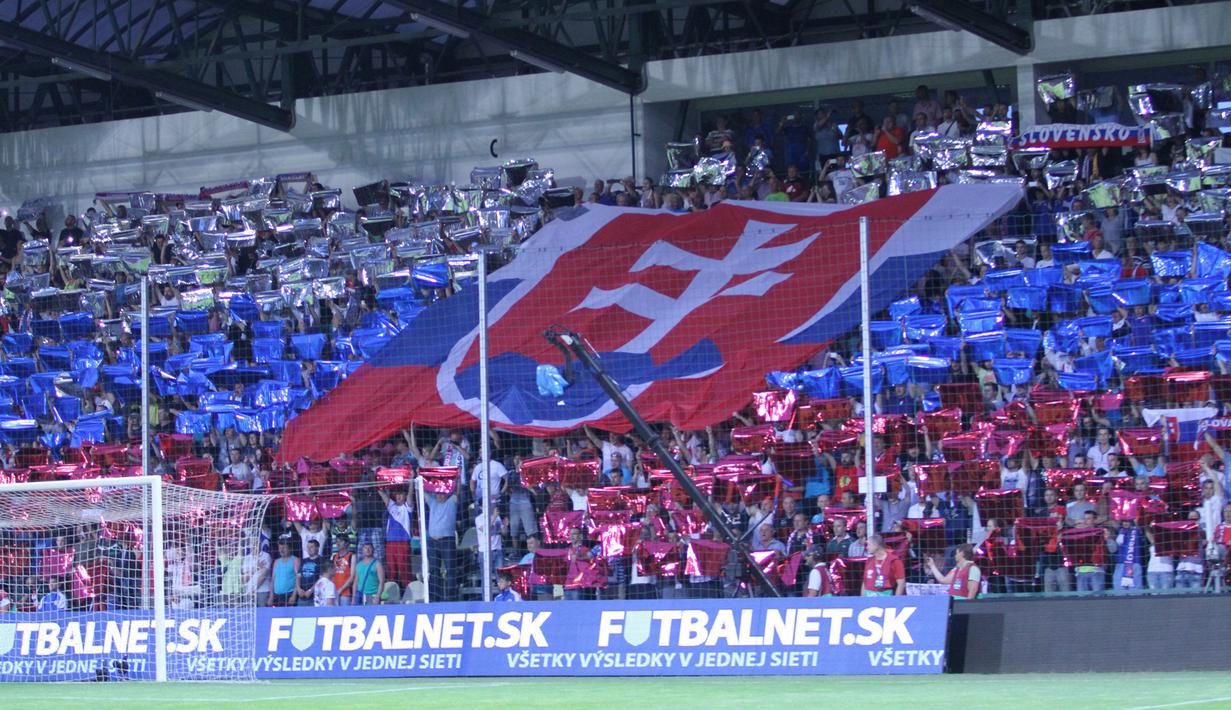  Suporter Slowakia membentangkan bendera nasionalnya di tribun selatan Stadion MSK Zilina. (Bola.com/Reza Khomaini)