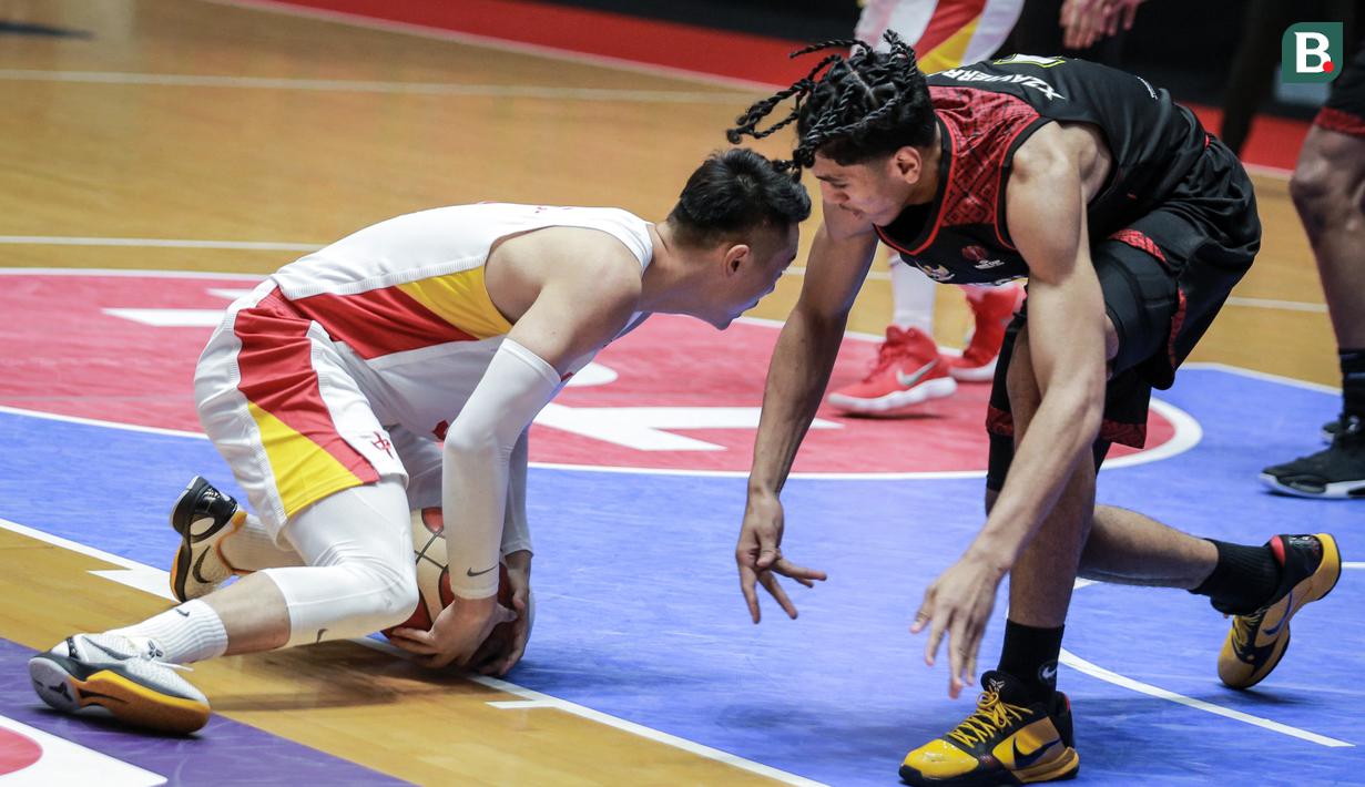 Pemain Timnas Basket Indonesia, Derrick Michael Xzavierro (kanan) berusaha merebut bola pemain Timnas Basket China, Zhai Xiaochuan saat laga playoff perempat final FIBA Asia Cup 2022 di Istora Senayan, Jakarta, Senin (18/07/2022). (Bola.com/Bagaskara Lazuardi)