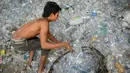 Pengumpul sampah memilih botol plastik di sebuah gudang sampah di Nusa Dua, di pulau resor Indonesia Bali (2/5). (AFP Photo/Sonny Tumbelaka)