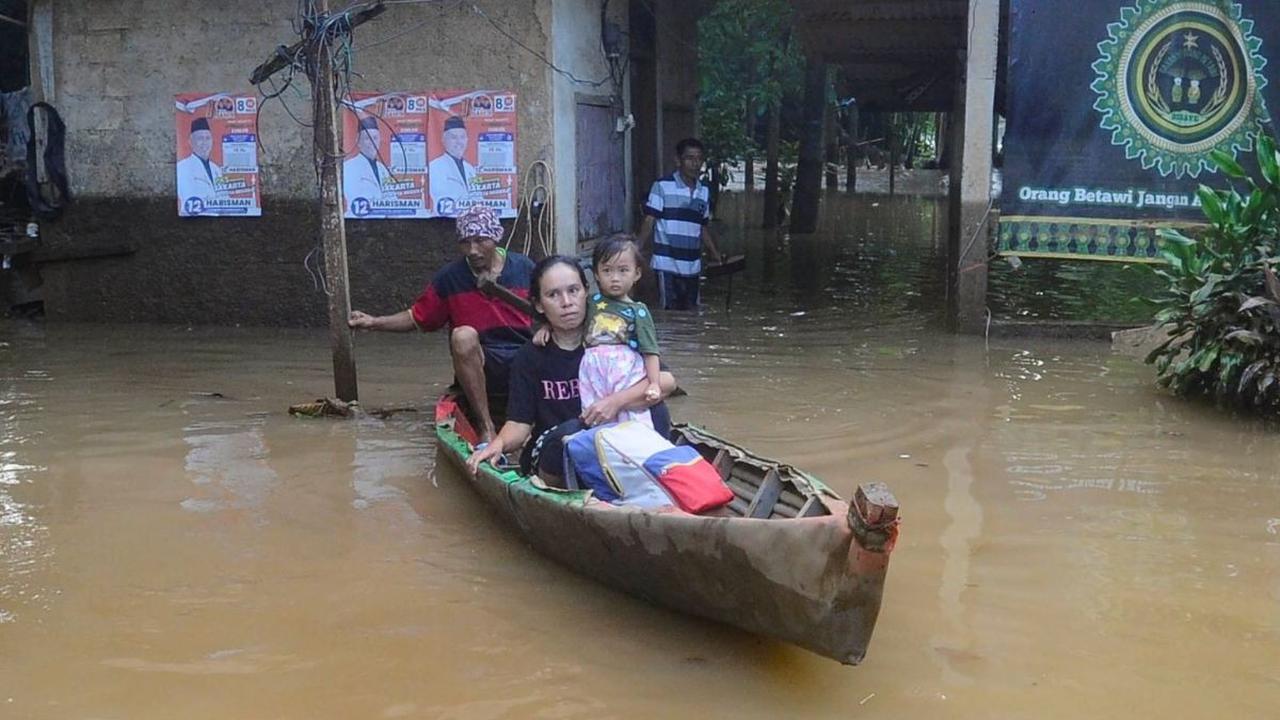 Warga menggunakan perahu saat banjir setinggi sekitar satu meter merendam kawasan Pejaten Timur, Jakarta selatan, Senin (23/03/2024). Foto: merdeka.com / Arie Basuki<br>
