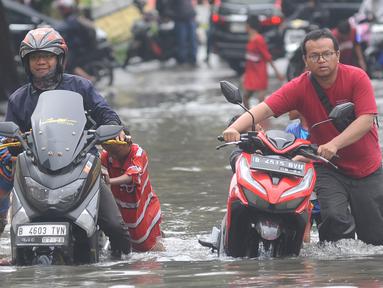 Kendaraan bermotor menerobos banjir di Jalan Daan Mogot Jakarta Barat, Rabu (14/2/2024). (merdeka.com/Arie Basuki)