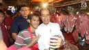 Presiden Joko Widodo atau Jokowi berswafoto dengan pedagang saat blusukan di Pasar Minggu, Jakarta, Jumat (22/2).Kehadiran Jokowi disambut antusias oleh warga dan pedagang. (Liputan6.com/Angga Yuniar)