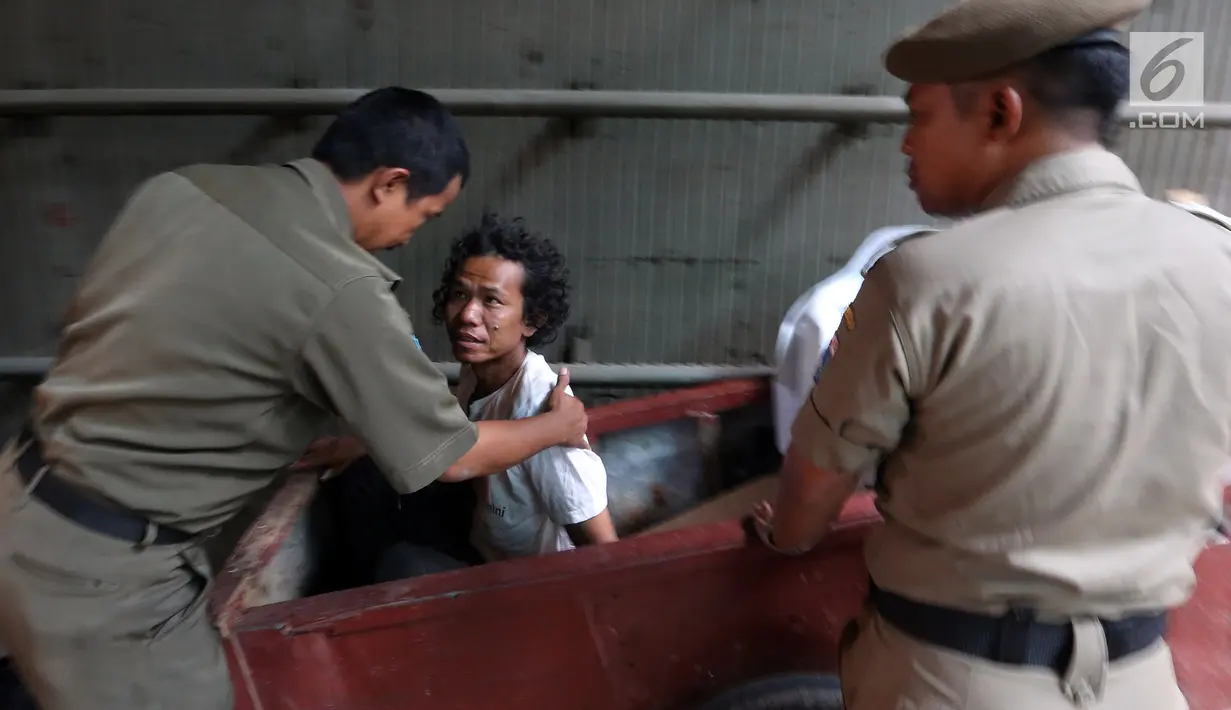 Petugas Satpol PP dari Kecamatan Setia Budi merazia tunawisma yang sedang berada dalam gerobaknya di Kawasan Kuningan, Jakarta, Rabu (15/11). Razia ini bertujuan untuk mengurangi dan memberantas penyakit masyarakat. (Liputan6.com/JohanTallo)