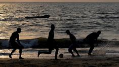 Anak-anak muda Gabon bermain sepak bola di tepian pantai  di Libreville (17/1/2017). Demam Piala Afrika 2017 menjadikan Gabon sebagai salah satu tujuan wisata sekaligus ajang mencari bakat-bakat muda Afrika.  (AFP/Gabriel Bouys)