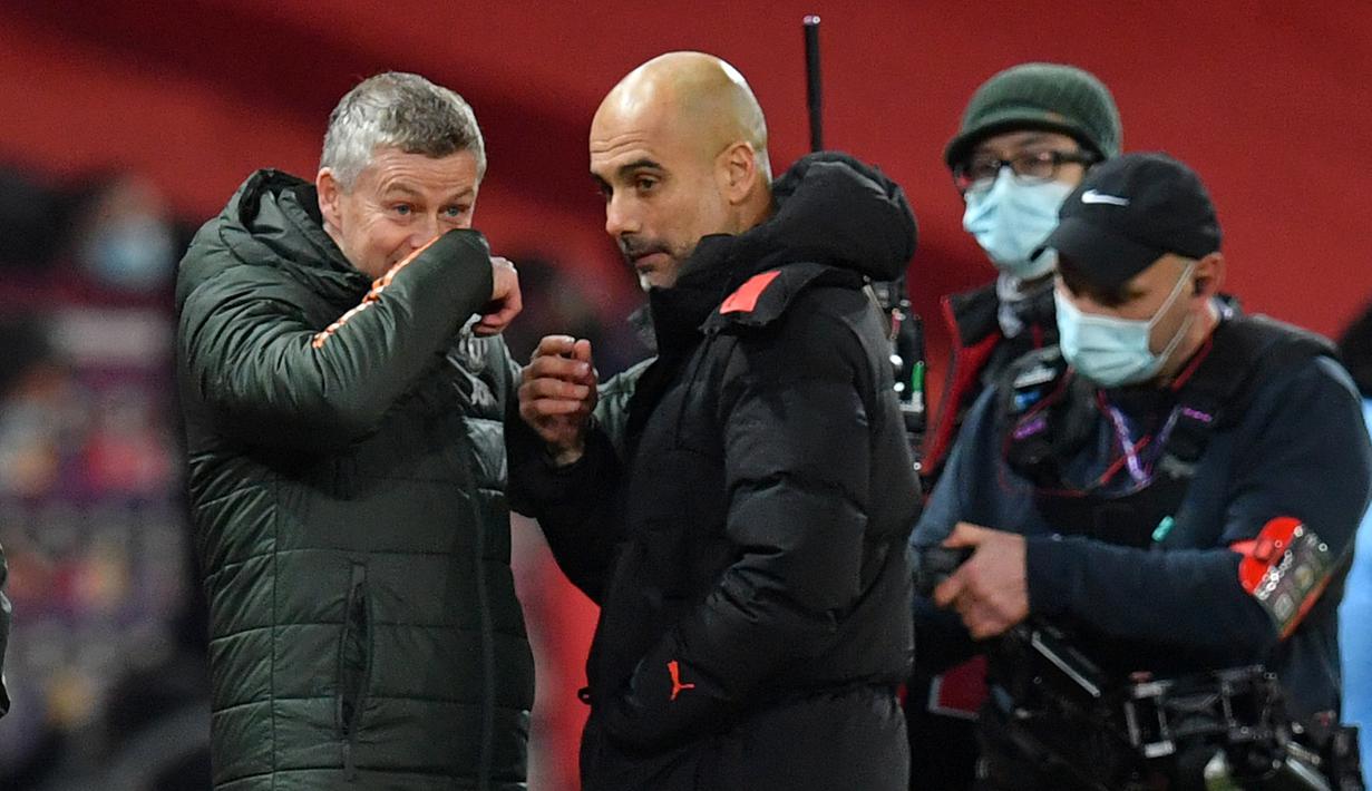 Manajer Manchester United, Ole Gunnar Solskjaer (kiri), berbincang dengan manajer Manchester City, Josep Guardiola usai laga lanjutan Liga Inggris 2020/21 pekan ke-12 di Old Trafford Stadium, Sabtu (12/12/2020). Manchester United bermain imbang 0-0 dengan Manchester City. (AFP/Paul Ellis/Pool)