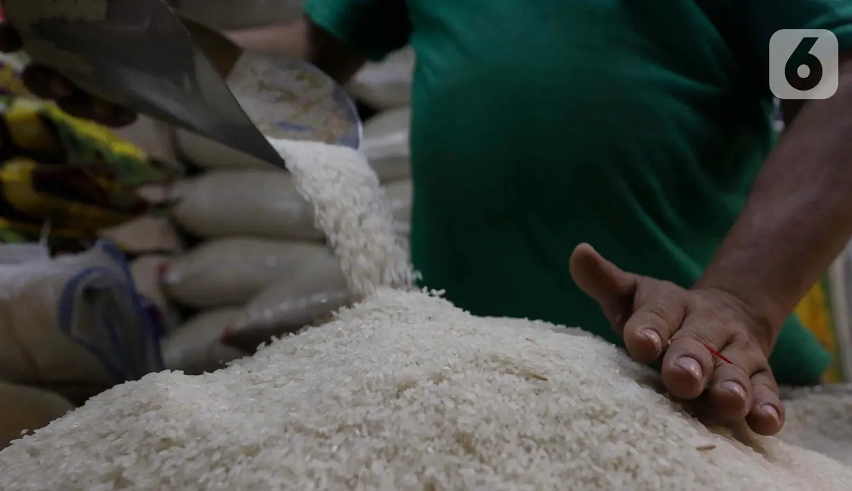 Pedagang memeriksa kondisi beras di pasar Cibubur, Jakarta, Senin (19/2/2024). (Liputan6.com/Herman Zakharia)