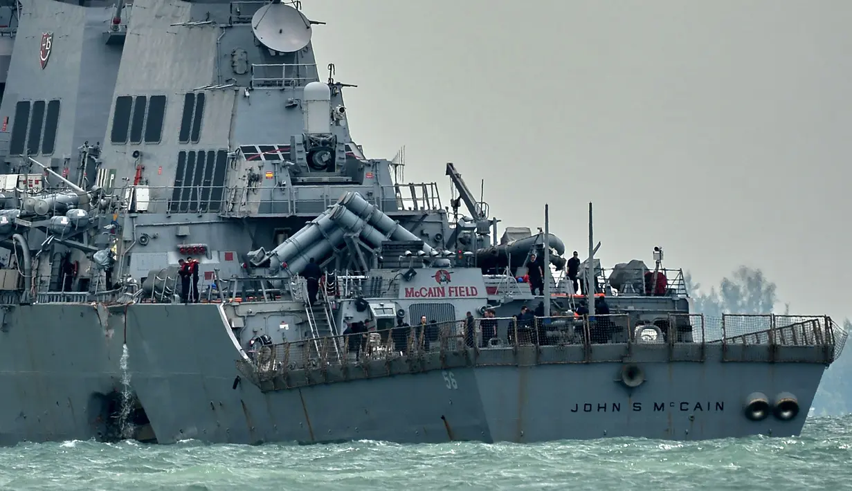 Petugas mengecek Lambung kiri kapal perang USS John S. McCain usai tabrakan dengan kapal tanker Alnic MC berbendera Liberia di Selat Malaka, sebelah timur Singapura, (21/8). (AFP Photo/Roslan Rahman)