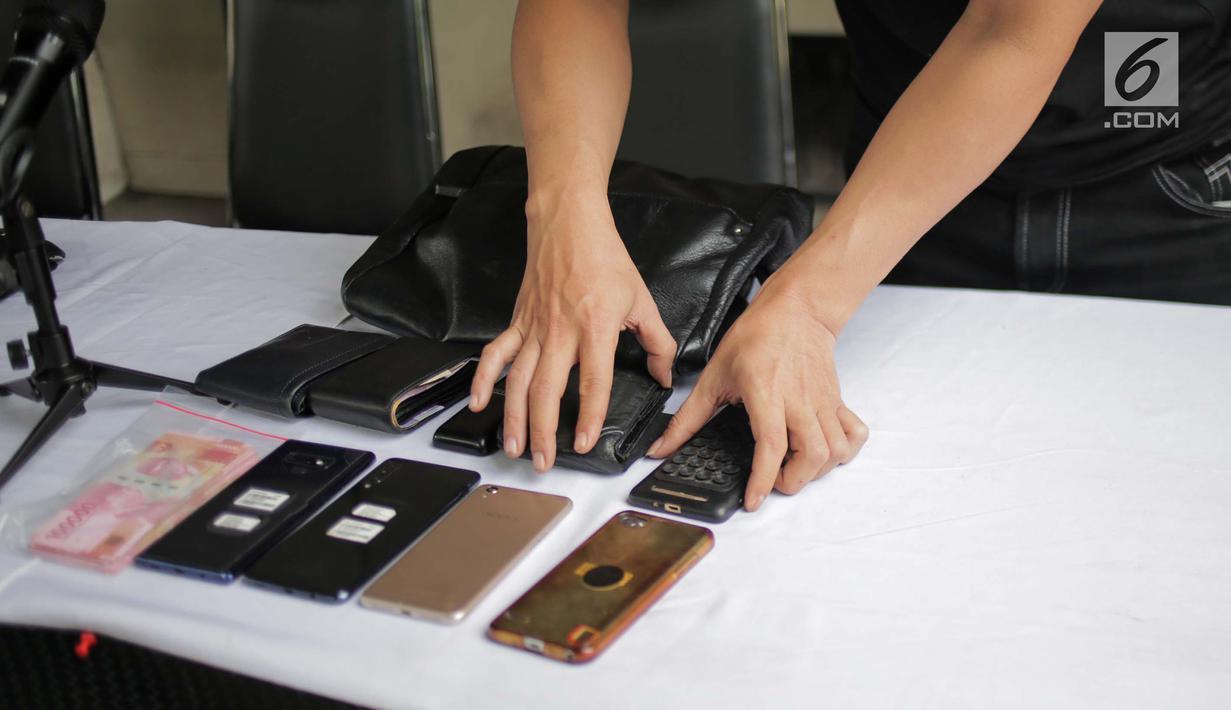 Petugas menunjukkan barang bukti saat rilis pengungkapan beberapa kasus di Subdit Resmob Polda Metro Jaya, Jakarta, Jumat (19/7/2019). Sebanyak 9 kasus dirilis Subdit Resmob Polda Metro Jaya yang diantaranya curas, jambret, pengganjalan ATM, dan penipuan lewat telepon. (Liputan6.com/Faizal Fanani)