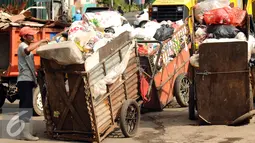 Pekerja menantikan waktu bongkar di Tempat Pembuangan Sampah Sementara Kalibata, Jakarta, Senin (4/1/2016). Dengan digantinya gerobak dengan sepeda motor diharapkan pengangkutan sampah bisa lebih cepat dan efisien. (Liputan6.com/Helmi Fithriansyah)