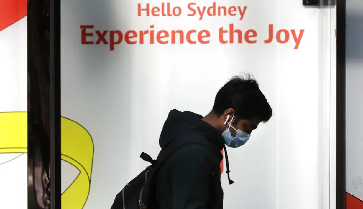 Seorang pria mengenakan masker saat berjalan di Sydney, pada Rabu (7/7/2021). Lockdown covid-19 selama dua pekan di Sydney telah diperpanjang seminggu lagi hingga 16 Juli karena kerentanan populasi Australia yang sebagian besar belum divaksinasi, kata para pejabat. (AP Photo/Rick Rycroft)