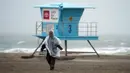 Seorang petugas pantai berjalan di sepanjang pantai di Huntington Beach, California, Amerika Serikat, 24 Februari 2023. California dan bagian lain di Barat menghadapi salju lebat dan hujan dari badai musim dingin terbaru yang melanda Amerika Serikat. (AP Photo/Ashley Landis)