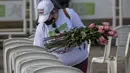 Seorang perempuan meletakkan bunga di atas bangku dengan nama petugas kesehatan yang meninggal karena COVID-19 selama protes terhadap sistem kesehatan di Bogota, Senin (26/10/2020). Kolombia pada Sabtu, 24 Oktober, melampaui satu juta kasus COVID-19 sejak dimulainya pandemi. (Juan BARRETO/AFP)