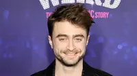 Daniel Radcliffe berpose sambil tersenyum saat menghadiri pemutaran perdana film "Weird: The Al Yankovic Story" di Alamo Drafthouse Cinema Downtown Brooklyn di New York pada Selasa, 1 November 2022. Radcliffe melanjutkan dengan tema hitam, mengenakan sepasang sepatu untuk acara tersebut. (Theo Wargo/Getty Images/AFP)