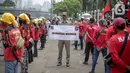 Petugas Satpol PP memegang poster imbauan protokol kesehatan COVID-19 saat unjuk rasa buruh di depan Gedung DPR, Jakarta, Selasa (17/11/2020). Pemerintah terus mengingatkan pentingnya 3M yaitu memakai masker, menjaga jarak, dan mencuci sebagai upaya pencegahan Covid-19. (Liputan6.com/Faizal Fanani)