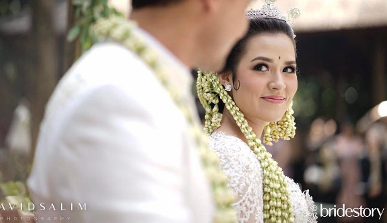 Penyanyi Raisa tersenyum dihadapan sang suami Hamish Daud usai melangsungkan akad nikah. (Instagram/thebridestory)