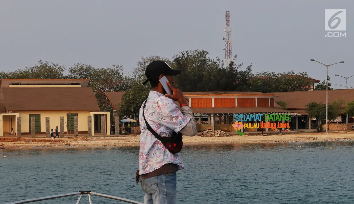Wisatawan melakukan telepon di dekat tower di Kepulauan Seribu, Rabu, 18/9/2019. PT Tower Bersama Infrastructure Tbk (TBIG) memiliki 26.713 penyewaan dan 15.344 site telekomunikasi tersebar di seluruh indonesia, ditargetkan akan menambah 3000 penyewaan di tahun 2019. (Liputan6.com/Johan Tallo)