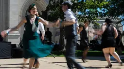 Para peserta mengenakan pakaian tahun 20-an menari saat acara Dardanella di Washington DC, AS (23/9). Dardanella awalnya adalah sebuah lagu populer yang diterbitkan pada tahun 1919 oleh Fred Fisher. (AFP Photo/Andrew Caballero)