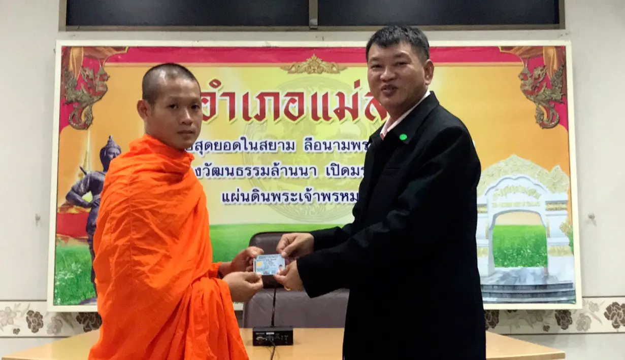 Pelatih sepakbola, Ekapol Chantawong menerima kartu identitas sebagai warga negara Thailand di distrik Mae Sai, Rabu (8/8). Korban gua Thailand tersebut selama ini hidup tanpa memiliki status kewarganegaraan (Chiang Rai Public Relations Office via AP)