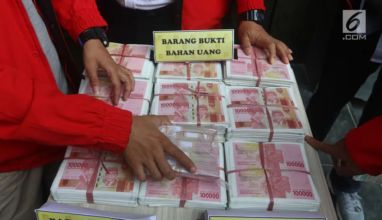 Petugas menunjukkan barang bukti saat rilis kasus pemalsuan dokumen dan uang palsu di Jakarta, Rabu (20/12). Bareskrim Polri mengamankan barang bukti berupa 22 unit kendaraan serta beberapa ikat uang palsu yang belum dipotong. (Liputan6.com/Angga Yuniar)