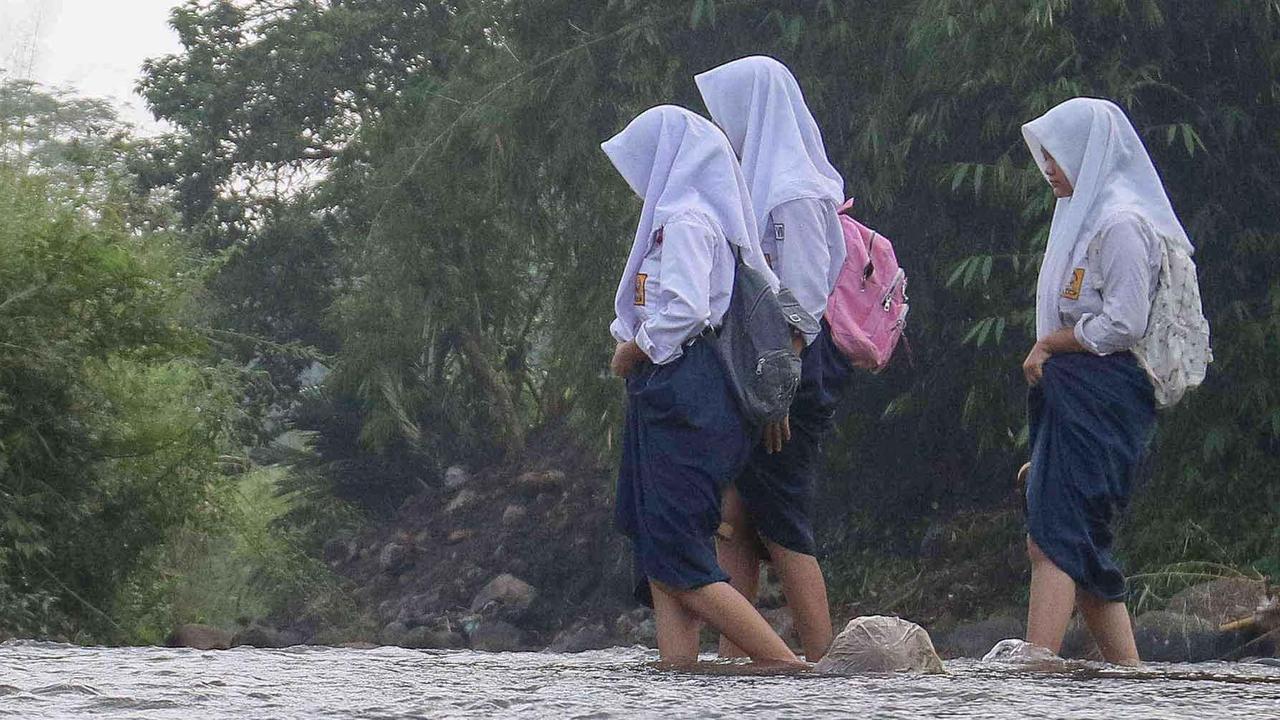 FOTO: Ketiadaan Jembatan  Penghubung Membuat Puluhan Siswa Menyeberang Sungai Menuju Sekolah di Dramaga Bogor