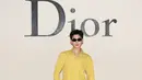 Deng Wei tampil vibrant dengan kemeja kuning berkerah dengan light jeans dan suede boots putih [Dior]
