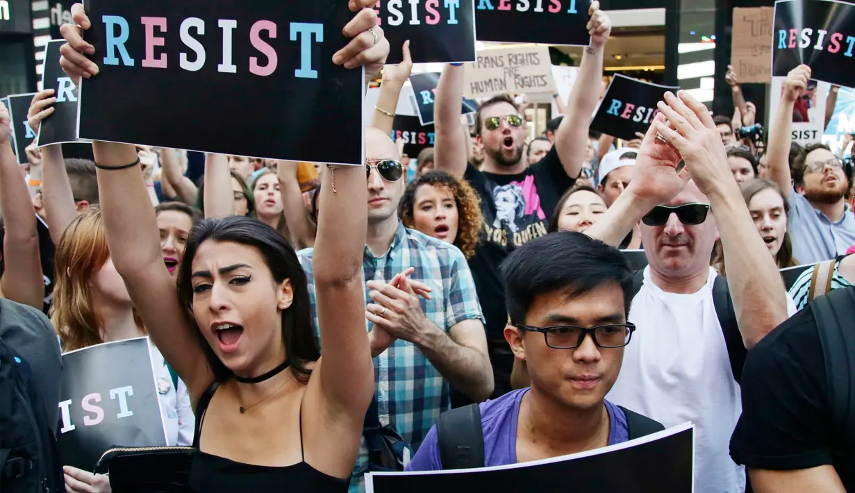 Sejumlah pendemo berorasi mengecam Donald Trump terkait larangan transgender masuk militer AS di Times Square, Rabu (26/7). Pemerintah belum memutuskan apakah transgender yang sudah bertugas di militer akan dikeluarkan atau tidak. (AP/Frank Franklin II)