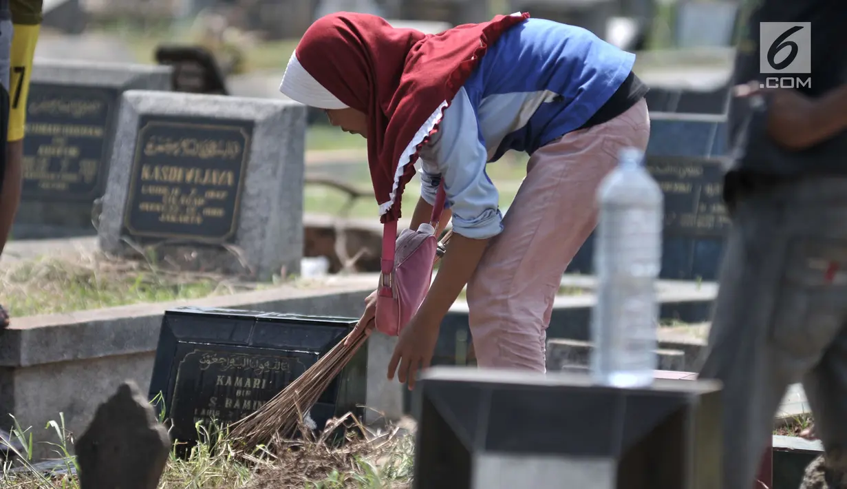 Seorang anak membersihkan salah satu makam di TPU Penggilingan, Pulogadung, Jakarta, Kamis (10/5). Tradisi ziarah jelang Ramadan menjadi berkah bagi anak-anak pembersih makam atau biasa dikenal 'Ngoret'. (Merdeka.com/Iqbal S. Nugroho)