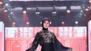 Paula Verhoeven tampil memikat dalam balutan dress hitam yang jatuh sleek mengikuti siluet tubuh. Detail motif bold dan selendang sheer memberi kesan teatrikal sekaligus mempertegas karakter koleksi yang bold. [Dok/Shi by Shireen & Zaskia Sungkar].