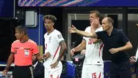 Pelatih Timnas Inggris, Thomas Tuchel, memberikan instruksi kepada Nico O'Reilly (kiri) dan Dan Burn sebelum keduanya masuk sebagai pemain pengganti pada laga semifinal Piala Dunia 2026 melawan Argentina di Atlanta Stadium, Atlanta, Kamis (16/7/2026)  dini hari WIB. (Richard Pelham/Getty Images/AFP)