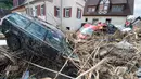 Mobil yang rusak disertai tumpukan ranting pohon yang terbawa oleh aliran arus banjir yang melanda wilayah Braunsbach, Jerman selatan (30/5). Empat orang tewas dan beberapa lainnya luka-luka dalam musibah ini. (Marijan Murat / dpa / AFP)