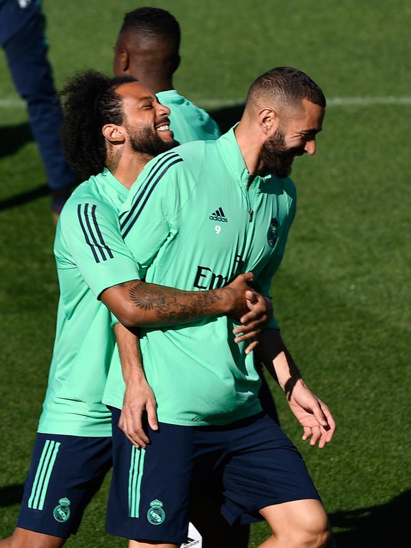 Bek Real Madrid Marcelo (kiri) bercanda dengan penyerang Karim Benzema saat sesi latihan di kompleks latihan Valdebebas, Madrid, Spanyol, Senin (30/9/2019). Real Madrid bersiap jelang menjamu Club Brugge dalam laga Liga Champions. (PIERRE-PHILIPPE MARCOU/AFP)