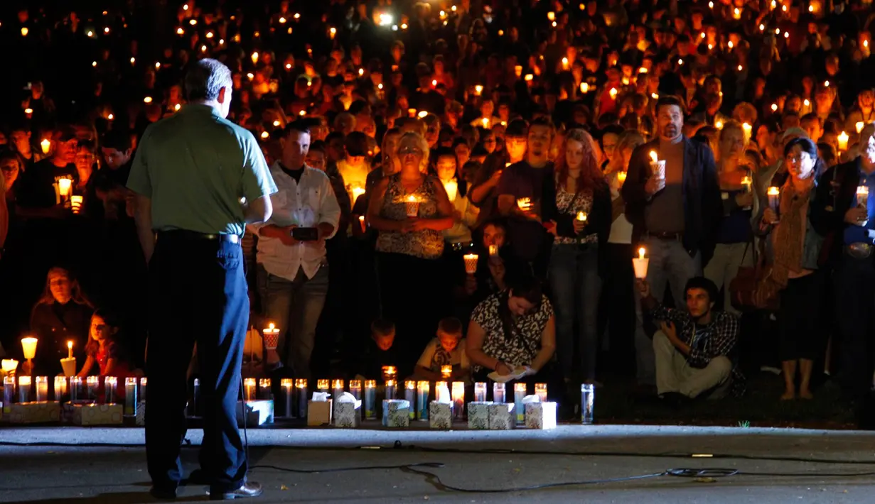 Sejumlah warga memegang lilin saat mengikuti aksi solidaritas terhadap penembakan masal di Umpqua Community College, Roseburg, Oregon, (1/10/2015). Pelaku penembakan tewas saat terlibat baku hantam dengan polisi. (REUTERS/Steve Dipaola)