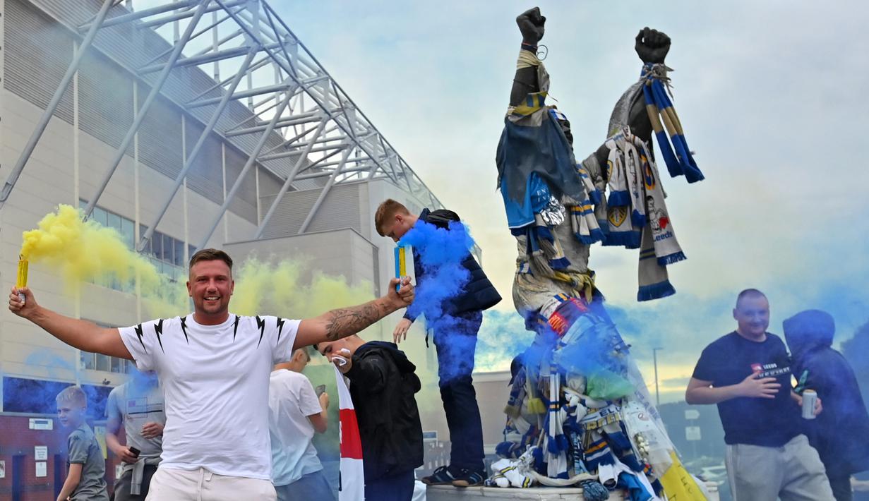 Suporter Leeds United merayakan keberhasilan timnya yang sukses kembali ke kompetisi Premier League di Elland Road, Leeds, Sabtu (18/7/2020). Leeds United dipastikan promosi ke Premier League musim 2020/2021 usai West Brom kalah 1-2 atas Huddersfield Town. (AFP/Paul Ellis)