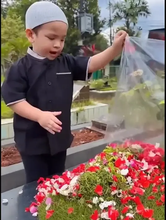 Tampak dalam videonya, Gala membawa plastik berisi bunga dan kemudian menuang di atas pusara orangtua. [TikTok/dianaalstri22]