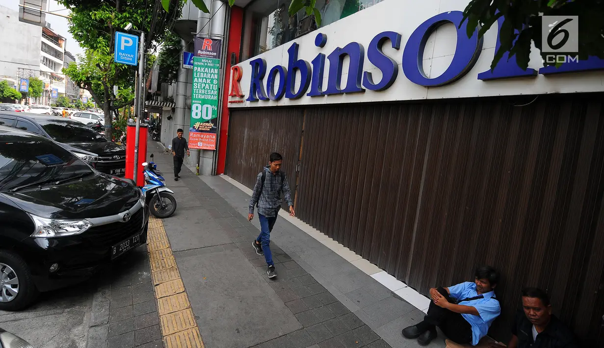 Pejalan kaki melintas di depan pertokoan yang tutup di Jalan Sabang, Jakarta pada Rabu (22/5/2019). Pemilik toko dan pengelola kantor di kawasan tersebut menutup toko dan kantor mereka imbas aksi 22 Mei 2019 yang berakhir rusuh di beberapa titik lokasi. (Liputan6.com/Aangga Yuniar)