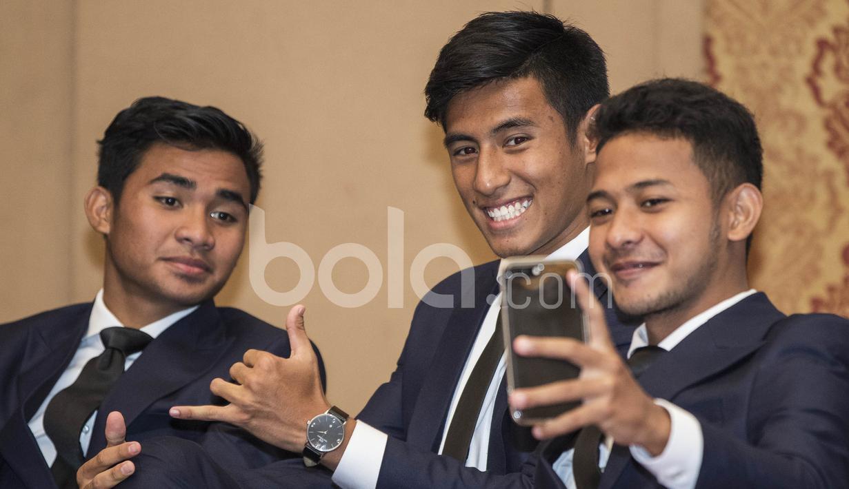 Pemain Timnas Indonesia U-22, Gian Zola, Hanif Sjahbandi (tengah) dan Asnawi Mangkualam (kiri), melakukan selfie. Dengan memakai pakaian ini Timnas U-22 diharapkan bisa tampil lebih elegan membawa citra bangsa. (Bola.com/Vitalis Yogi Trisna)