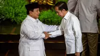 Presiden Republik Indonesia Prabowo Subianto (kiri), yang juga Ketua Umum Partai Gerakan Indonesia Raya (Gerindra), dan Presiden Republik Indonesia ke-7 Joko Widodo saling menyapa di atas panggung pada puncak perayaan ulang tahun ke-17 Partai Gerindra di Sentul International Convention Center (SICC), Bogor, Jawa Barat, Sabtu (15/2/2025). (ADITYA AJI/AFP)