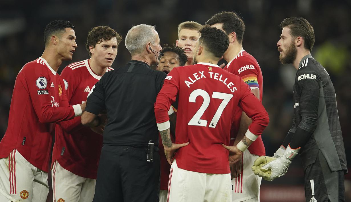 Para pemain Manchester United memprotes gol tersebut. Emile Smith-Rowe dinilai tidak sportif karena mencetak gol saat David De Gea terkapar usai terinjak Fred. Melalui rekaman VAR, wasit Martin Atkinson tetap mensahkan gol tersebut. (AP/Dave Thompson)