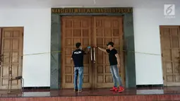 Petugas memasang garis polisi usai penyerangan di Gereja St Lidwina Bedog, Sleman, Yogyakarta, Minggu (11/2). Terduga pelaku telah berhasil dilumpuhkan polisi. (Liputan6.com/Arya Manggala)