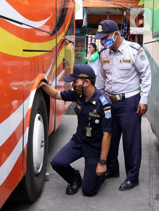 Petugas Dinas Perhubungan mengecek ban saat menginspeksi keselamatan bus di Terminal Kalideres, Jakarta, Selasa (22/12/2020). Inspeksi dilakukan untuk memastikan bus AKAP layak jalan untuk mengantar para pemudik jelang libur Natal dan Tahun Baru 2021. (Liputan6.com/Angga Yuniar)