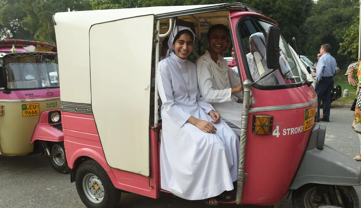 Para biarawati Pakistan duduk dengan becak merah muda sebelum aksi untuk meningkatkan kesadaran wanita di Lahore, (14/10). Becak merah muda dipegang oleh sekelompok wanita untuk menunjukkan kesetaraan dan pemberdayaan perempuan. (AFP PHOTO / Arif Ali)