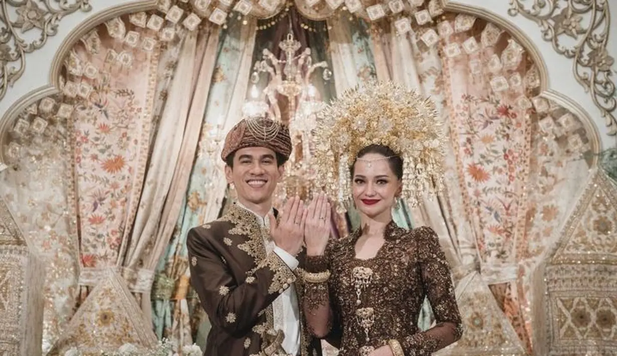 Saat akad nikah, Enzy memakai kebaya nuansa cokelat dan gold. Untuk makeup, atensi tertuju pada riasan mata yang intens dan lipstik merahnya yang tegas. [Foto: Instagram @enzystoria]
