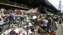 Para pedagang menjajakan dagangannya di luar pasar senen, Jakarta, Sabtu (21/1). Pasca kebakaran tidak membuat para pedangang putus asa, sebagian dri mereka ada yang tetap berjualan meskipun harua di bahu jalan. (Liputan6.com/Angga Yuniar)